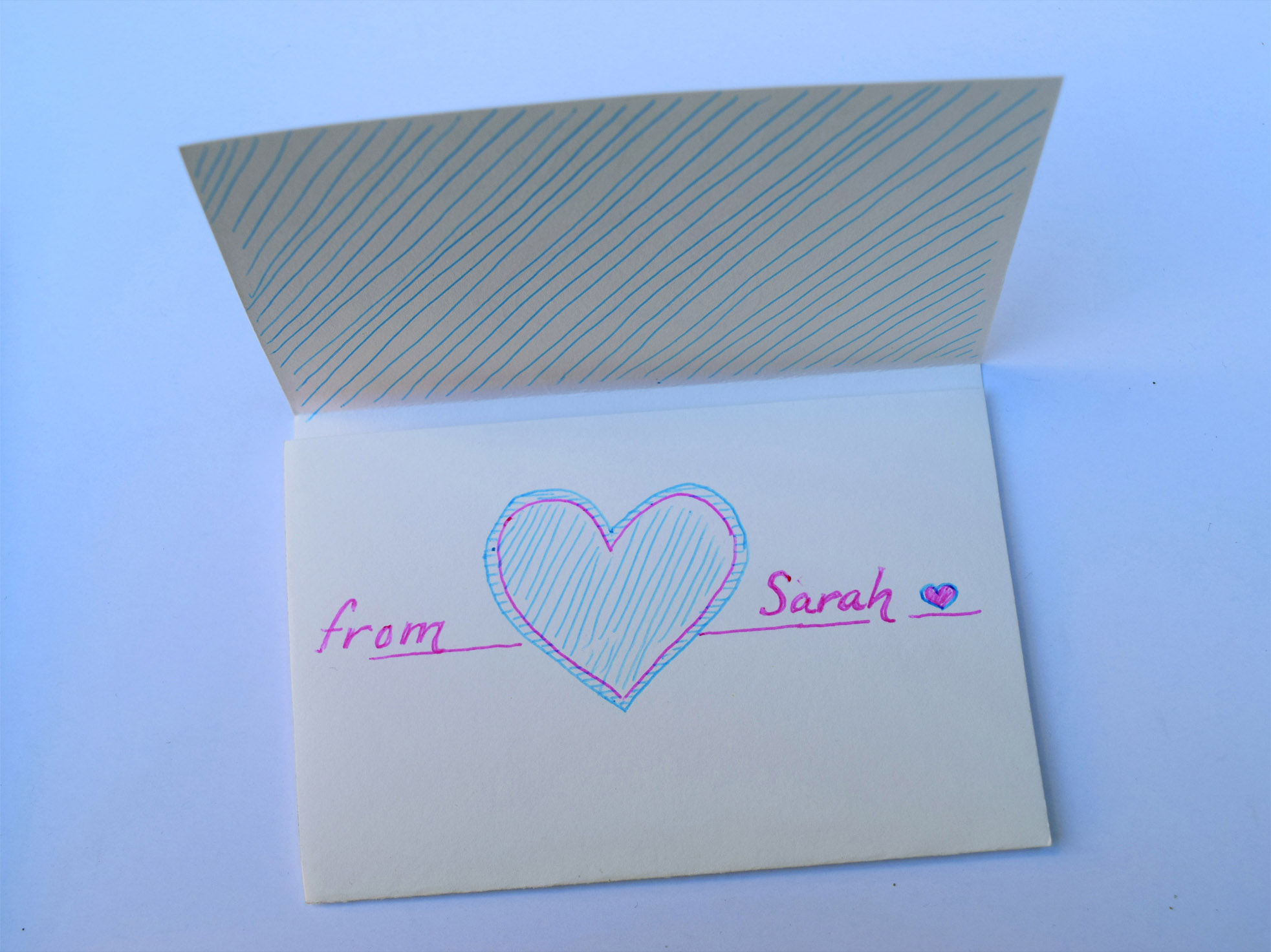 Half-open letter with the text 'from Sarah' written on the front around a drawn, large heart