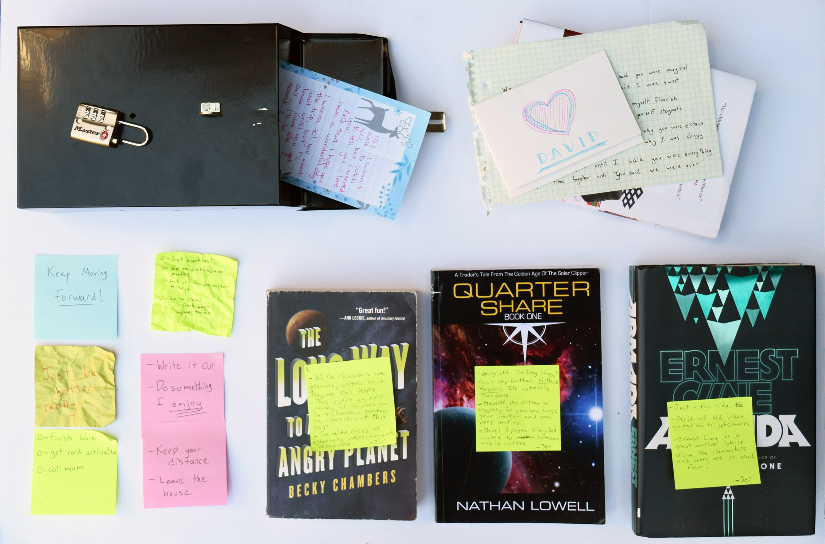 View full size version of laid-out books, post-its, letters and lock box