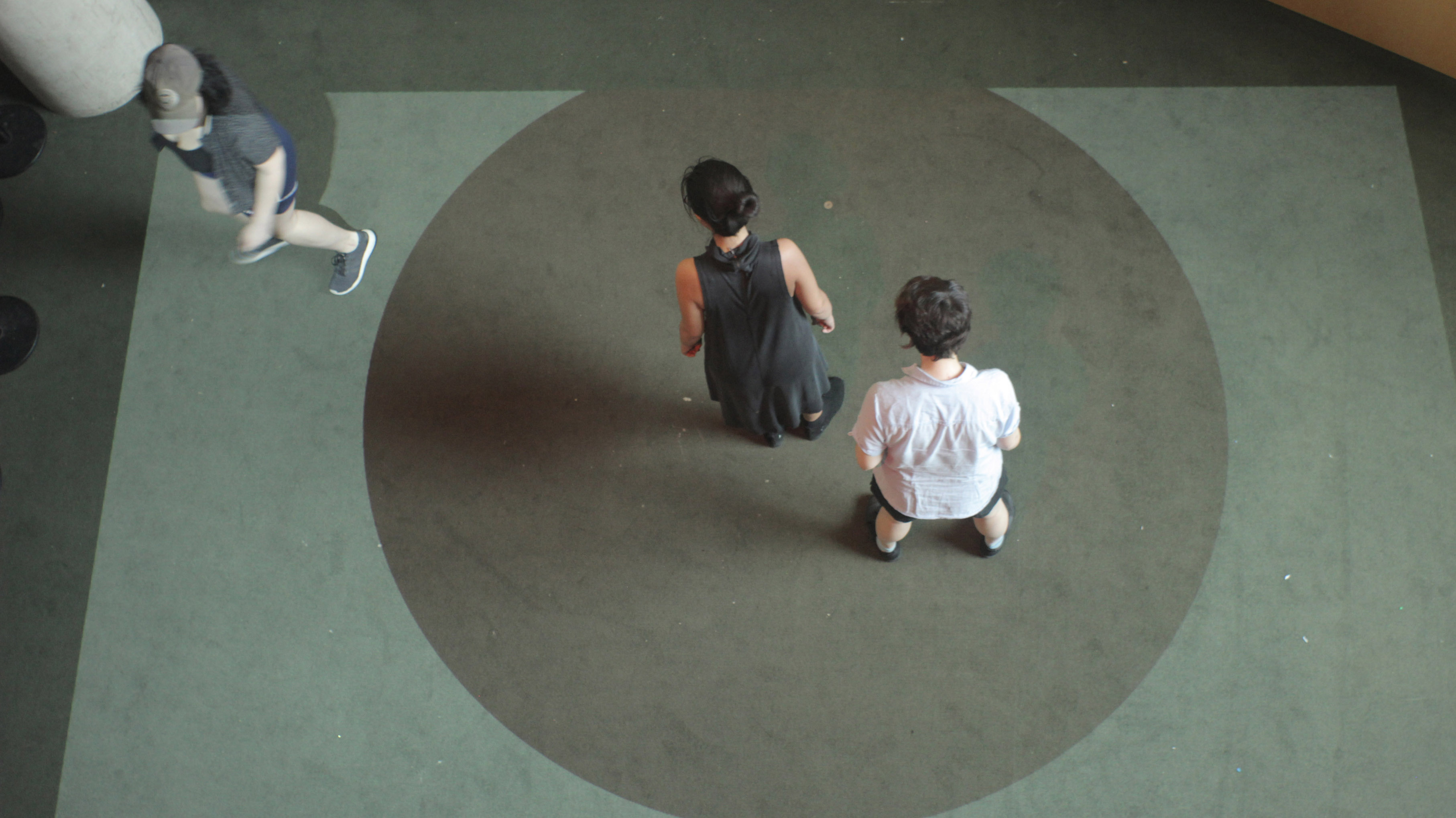 View full size version of a bird's-eye view of two people standing in a projected circle